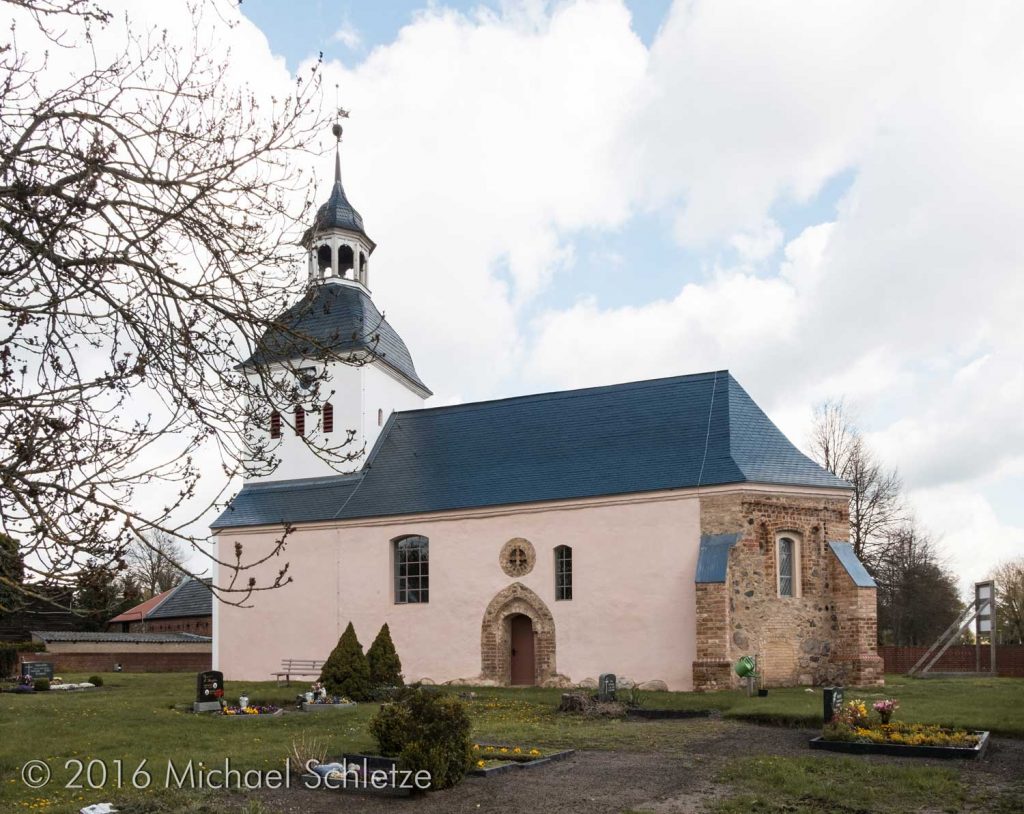 2016: Neu verputzte Kirche mit Turm und Haube, gelichtete Vegetation auf dem Friedhof